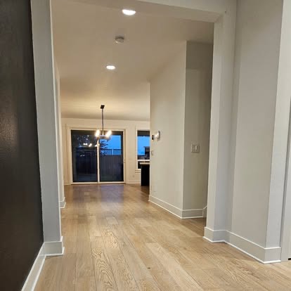 Long hallway with light wood floors