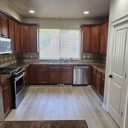 Clean kitchen with dark wood cabinets and stainless appliances
